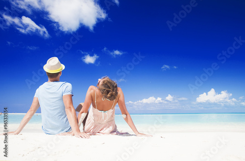 Photography back view of romantic couple in bright clothes enjoying sunny day at tropical be