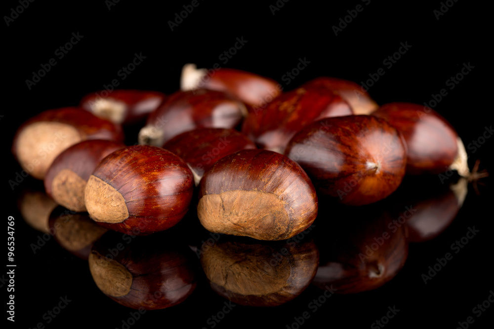 Fototapeta premium Chestnuts on a black reflective background