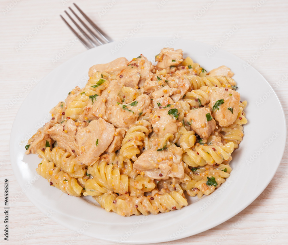 Sliced fried chicken fillet in a creamy and mustard sauce. with fusilli pasta