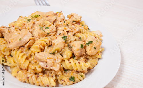 Sliced fried chicken fillet in a creamy and mustard sauce. with fusilli pasta