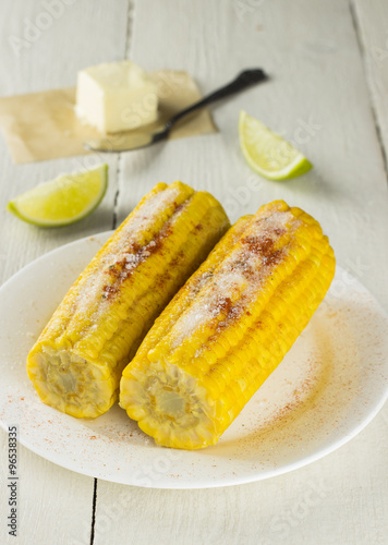 Corncob, butter, lime on white wooden table