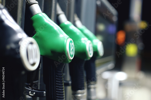 Green fuel pistols on fuel station.