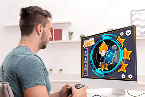 Young man playing computer ...
