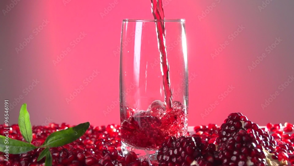 Garnet. Pomegranate juice is poured into a glass.  Slow motion 240 fps.