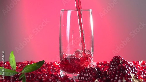 Garnet. Pomegranate juice is poured into a glass.  Slow motion 240 fps.