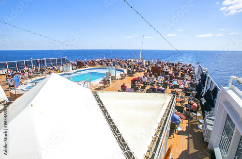 Bilde på lerret Tourists relax and take a sun bath on the upper deck of a cruise