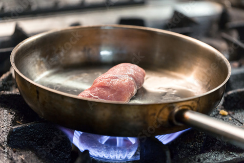 cooking meat in a frying pan