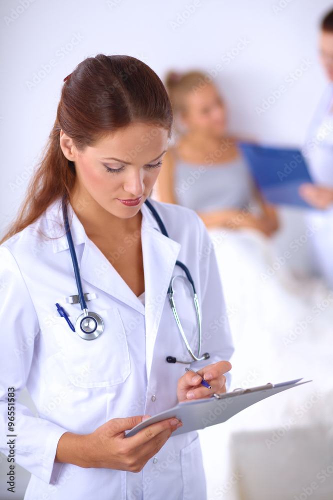 Smiling female doctor with a folder in uniform standing at hospital Smiling female doctor with a folder in uniform standing at hospital