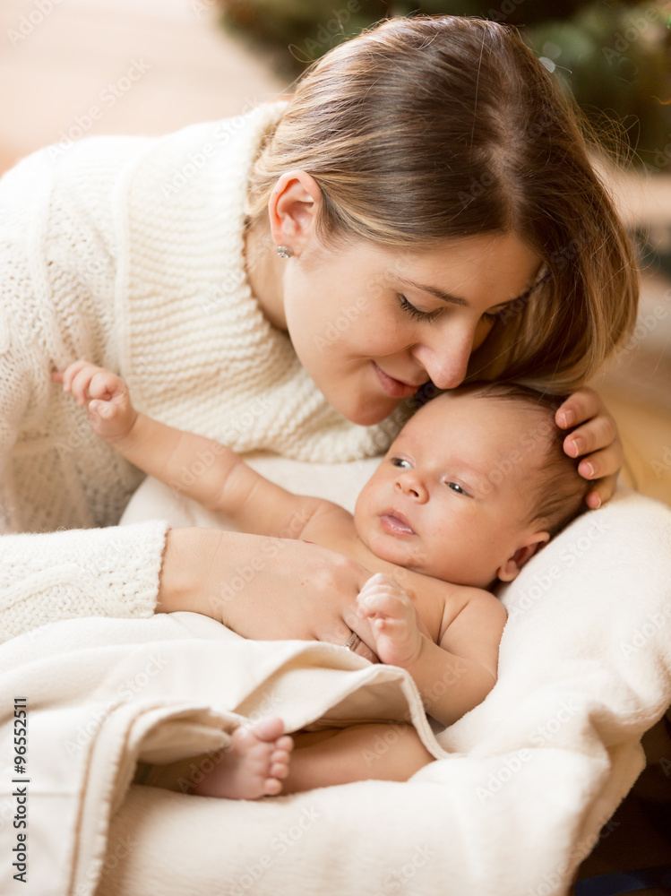 portrait of caring mother kissing baby boy son lying on white bl portrait of caring mother kissing baby boy son lying on white bl