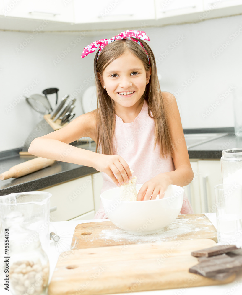 little girl with pink bow on hair making dough in big bowl little girl with pink bow on hair making dough in big bowl