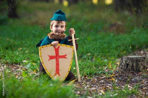 Cute little knight playing in the forest