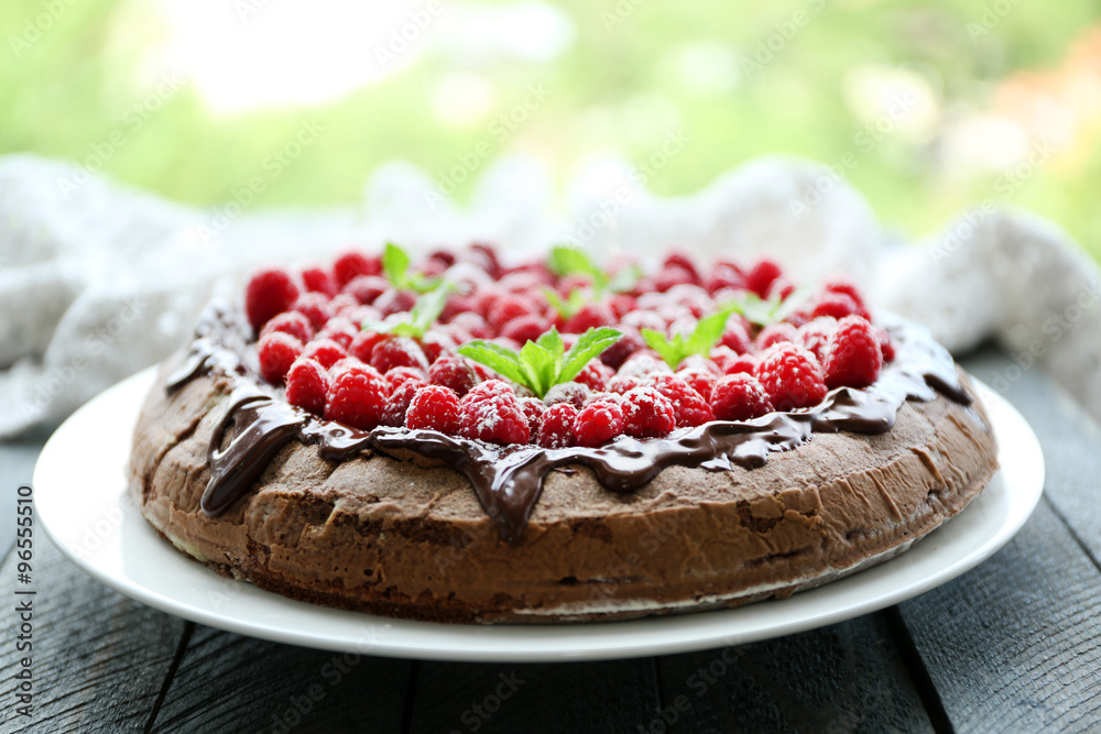 Cake with Chocolate Glaze and raspberries on wooden background