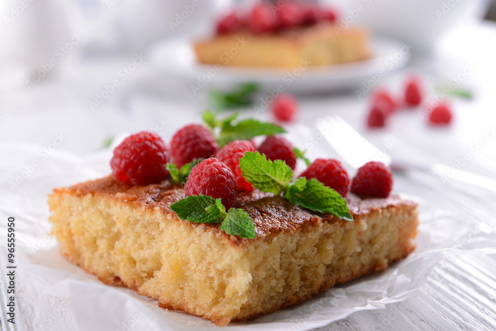 Fresh pie with raspberry on parchment on wooden table, closeup Fresh pie with raspberry on parchment on wooden table, closeup
