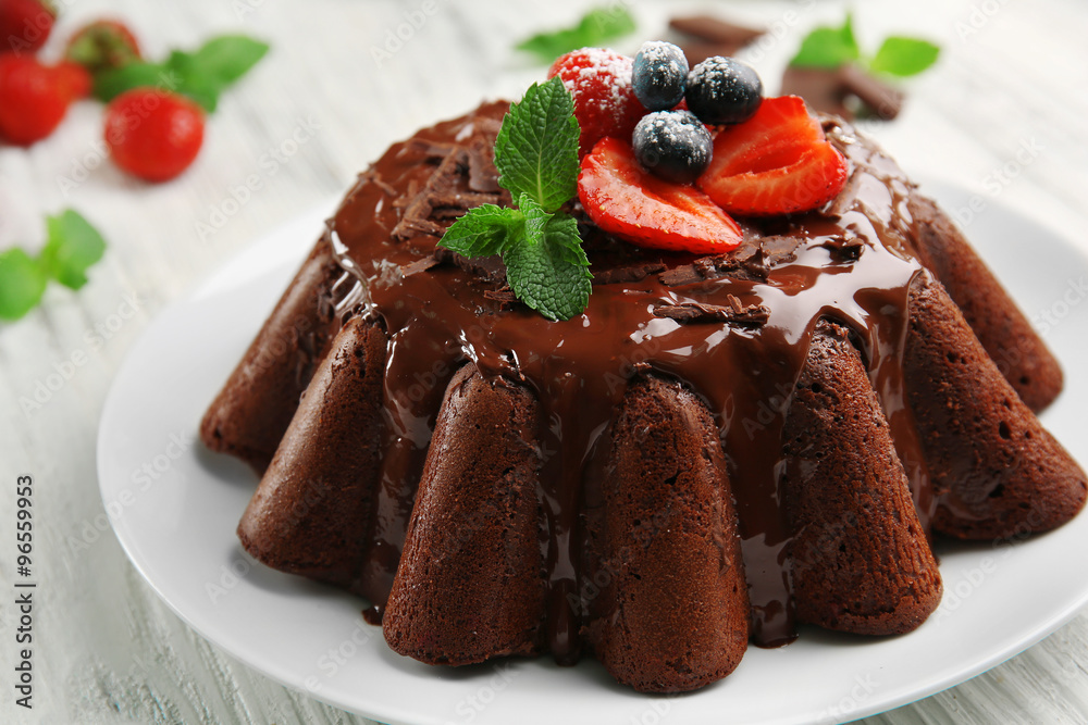 Delicious chocolate cake with berries in plate on table, closeup Delicious chocolate cake with berries in plate on table, closeup