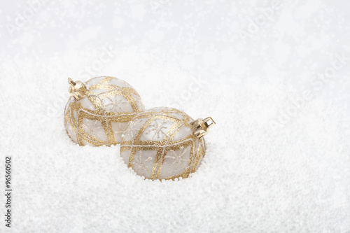 Gold and white baubles in fake snow