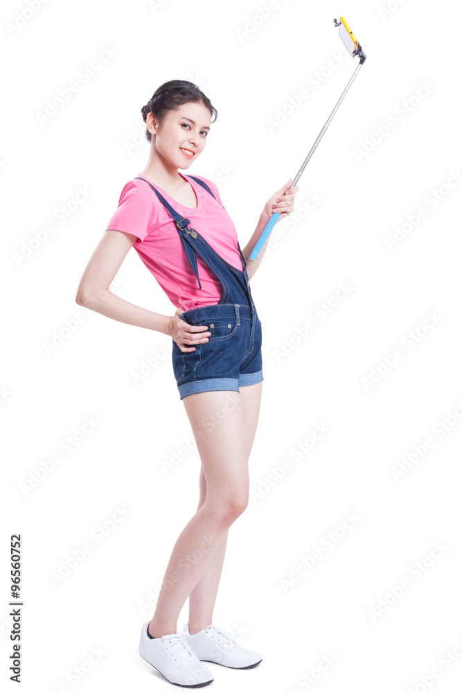 Young woman taking picture with smartphone selfie stick Young woman taking picture with smartphone selfie stick