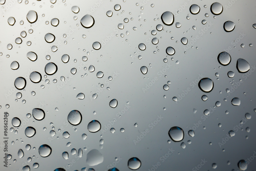 closeup water drop on glass mirror background.