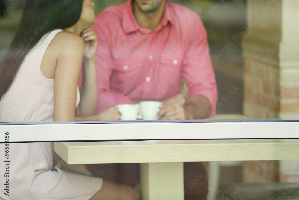 Young couple drinking tea and talking in cafe Young couple drinking tea and talking in cafe