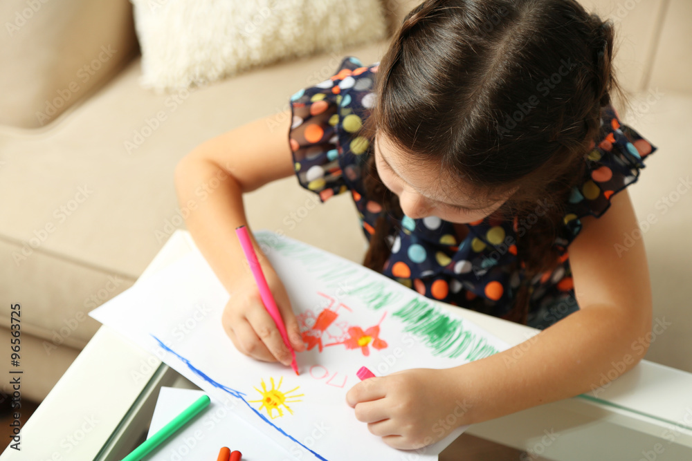 Cute little girl drawing picture on home interior background Cute little girl drawing picture on home interior background
