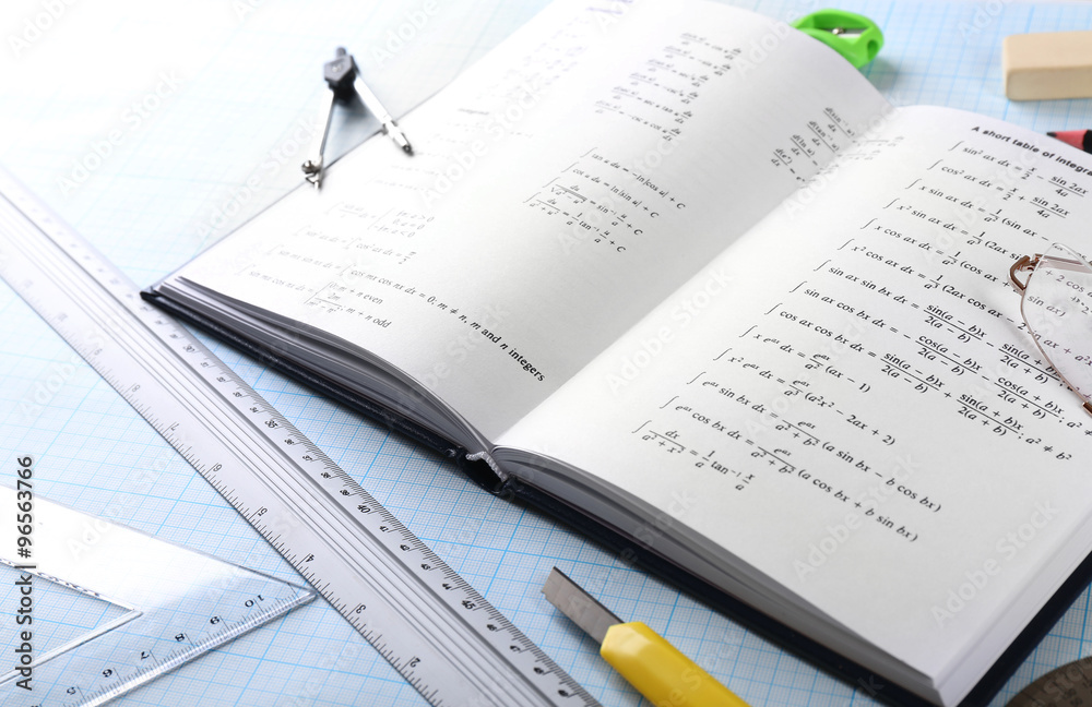 School supplies and textbook on mathematics close up School supplies and textbook on mathematics close up