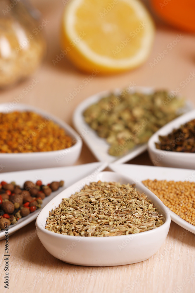 Variety of spices in ceramic containers on the kitchen table