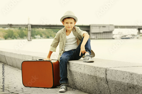 Little boy with suitcase on...