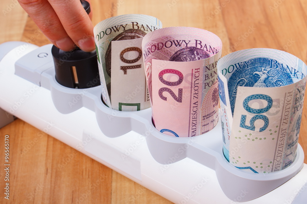 Hand of woman turns off electrical plug, polish currency money, energy costs Hand of woman turns off electrical plug, polish currency money, energy costs