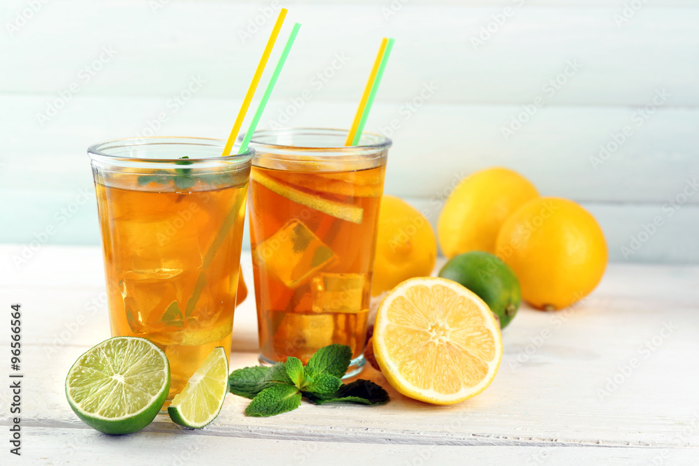 Fototapeta premium Iced tea with lemon on light wooden background