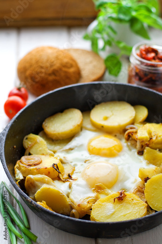 Fried potatoes with fried eggs, breakfast