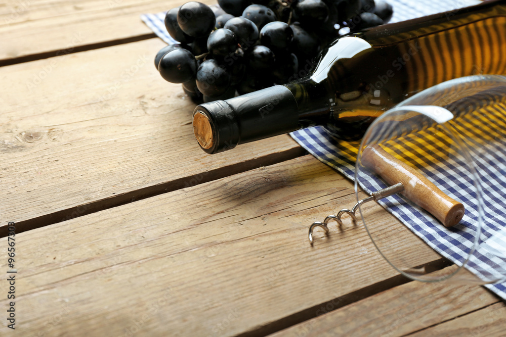 Obraz premium Bottle of wine and grape on wooden table