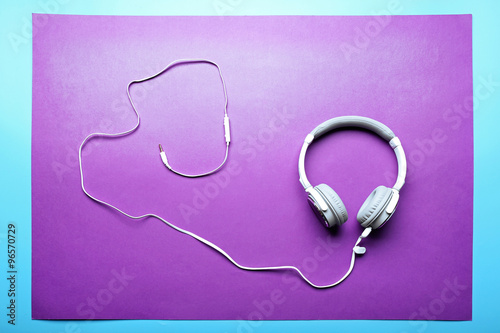 White and grey headphones on purple-blue background