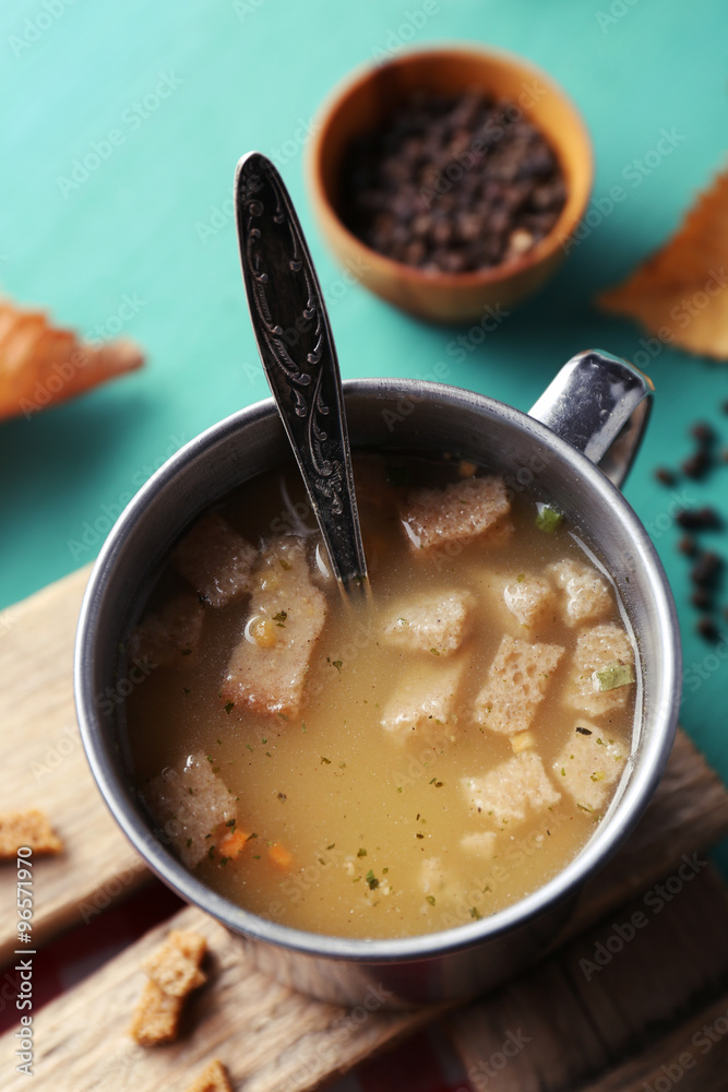 Mug of soup on wooden mat Mug of soup on wooden mat