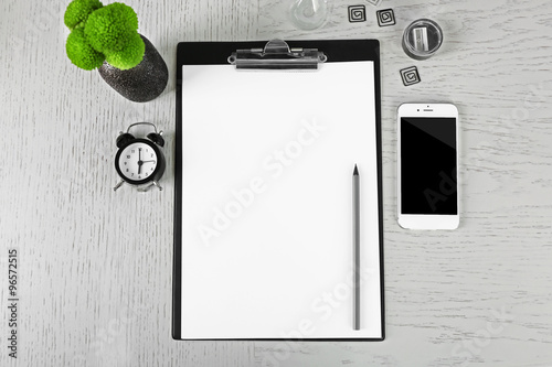 Cellphone with papers and stationery on white table