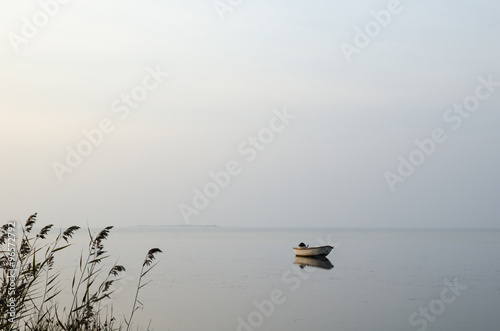 Foto Lone rowing boat in calm water
