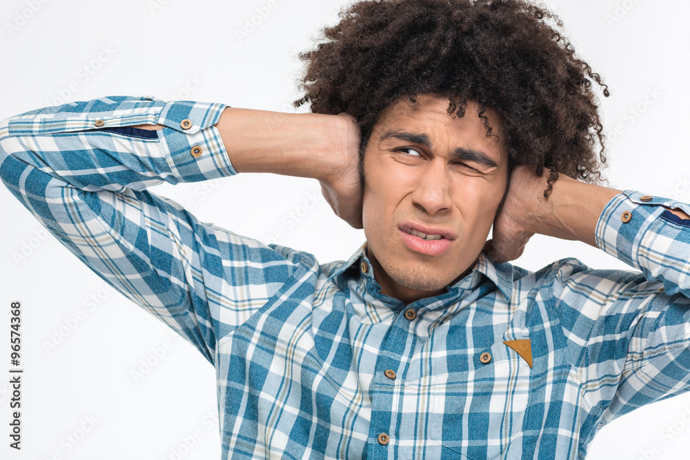 Depressed afro american man with curly hair covering his ears Depressed afro american man with curly hair covering his ears