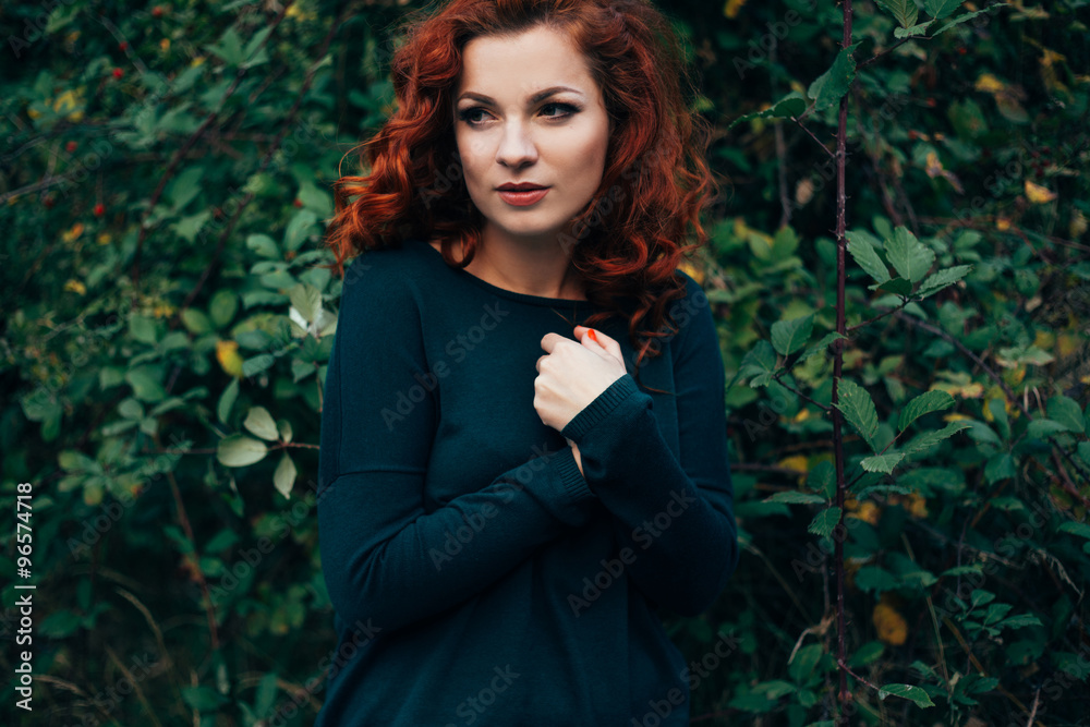 Beautiful young woman with bright red hair posing outdoors Beautiful young woman with bright red hair posing outdoors