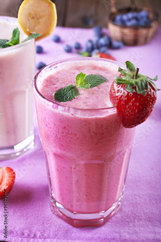 Glasses of fresh cold smoothie with fruit and berries, on the table, close-up