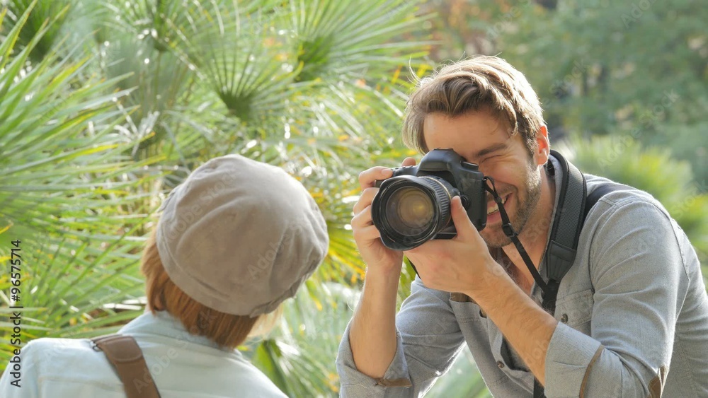 Photographer taking picture of trendy model in park Photographer taking picture of trendy model in park
