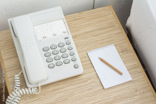 The phone on the table with a paper notebook and pencil. In the photo