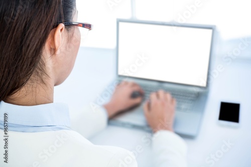 Rear view of businesswoman using laptop 