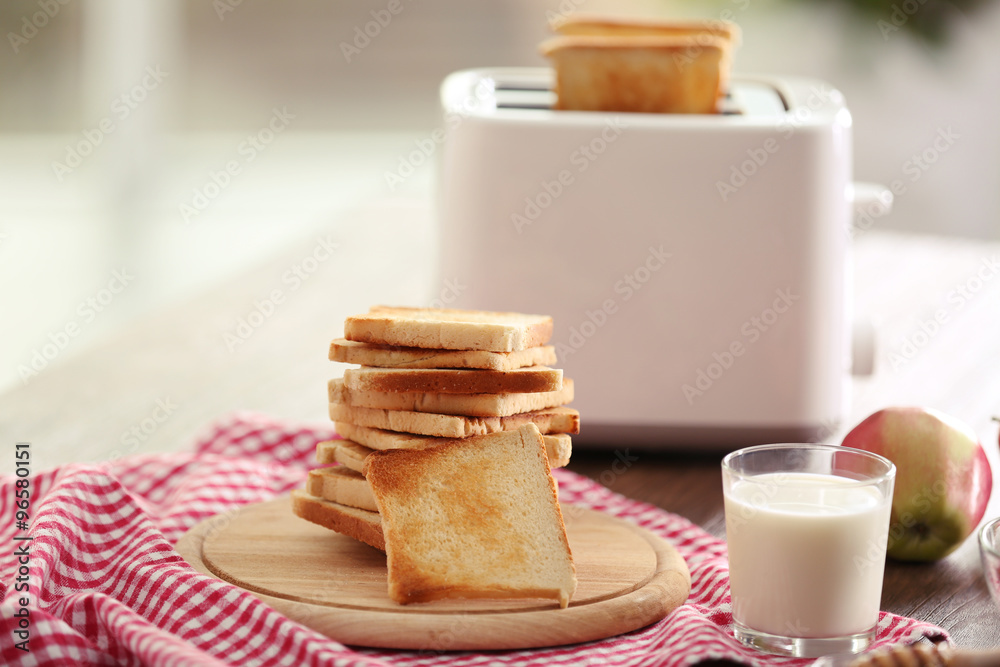 Served table for breakfast with toast, milk and honey, on blurred background