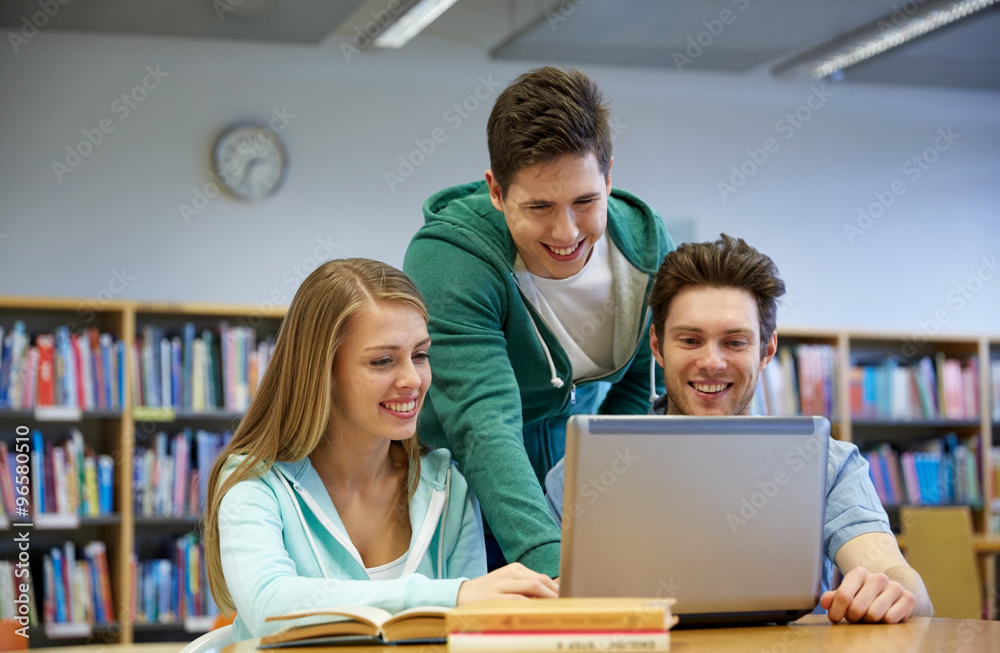 happy students with laptop in library happy students with laptop in library