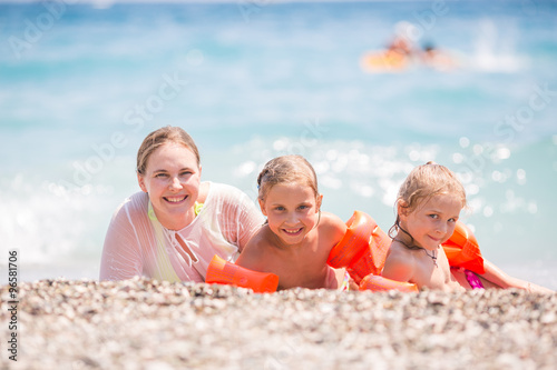 Happy mother with kids on the beach