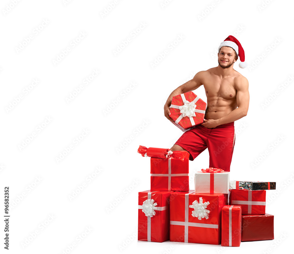 Feels like Christmas. Portrait of a toned man wearing Santa hat offering a pile of gifts isolated on white Feels like Christmas. Portrait of a toned man wearing Santa hat offering a pile of gifts isolated on white