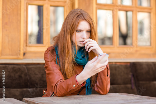 Embarrassed shoked lady reading message in mobile phone photo