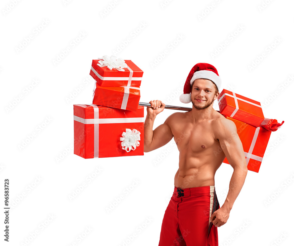 Say no to Christmas laziness. Studio portrait of a ripped and toned fitness man lifting weights with presents smiling looking away Say no to Christmas laziness. Studio portrait of a ripped and toned fitness man lifting weights with presents smiling looking away