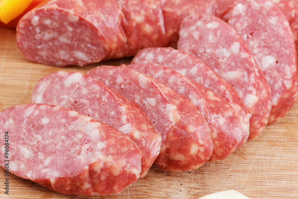 Sliced sausages with fat on a wooden board Sliced sausages with fat on a wooden board