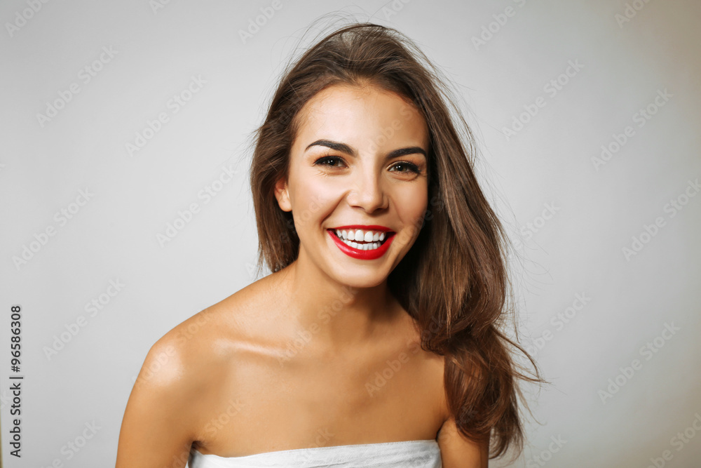 Young beautiful woman with a bandage on her chest smiling, on grey background Young beautiful woman with a bandage on her chest smiling, on grey background