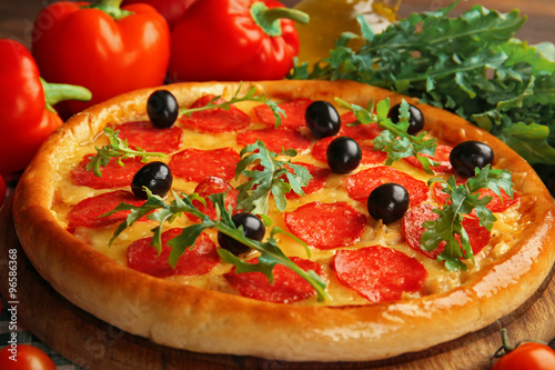 Tasty pizza with salami on decorated wooden table, close up