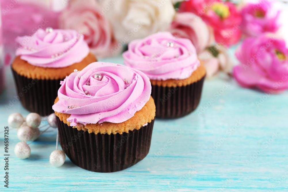 Tasty cupcakes and cup of tea on light background